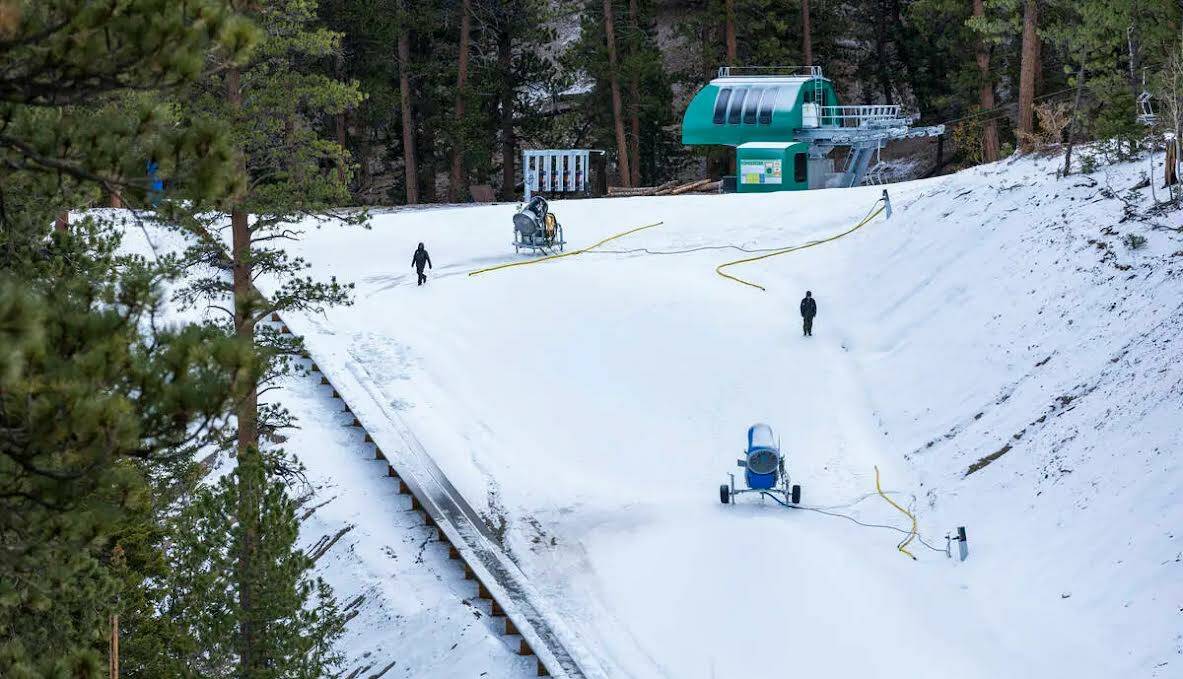 El personal de operaciones camina por una pendiente mientras comienza la producción de nieve e ...