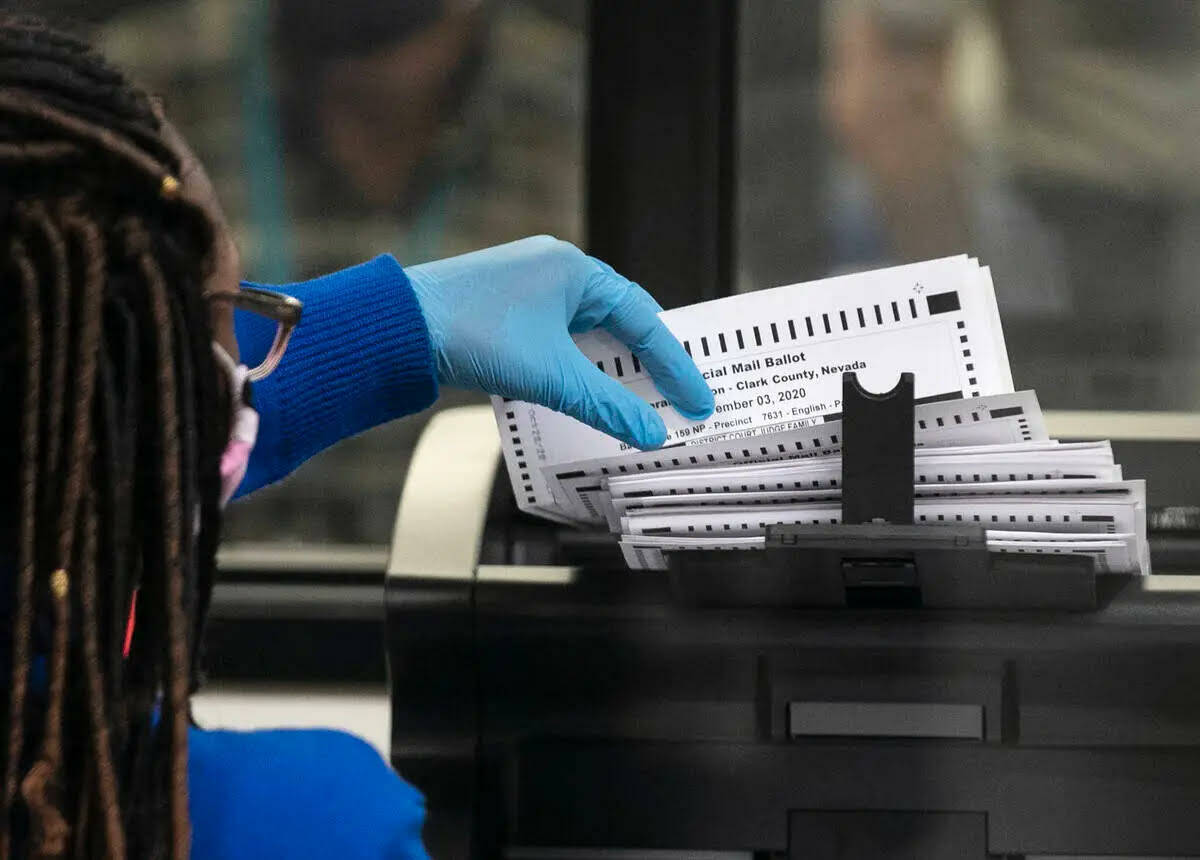 Un trabajador electoral del Condado Clark escanea boletas en el almacén del Departamento Elect ...