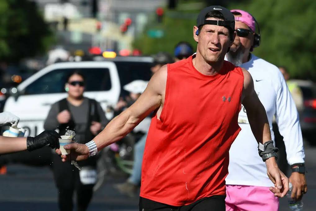 Un participante toma un vaso de agua durante el Maratón de Las Vegas, el domingo 3 de noviembr ...