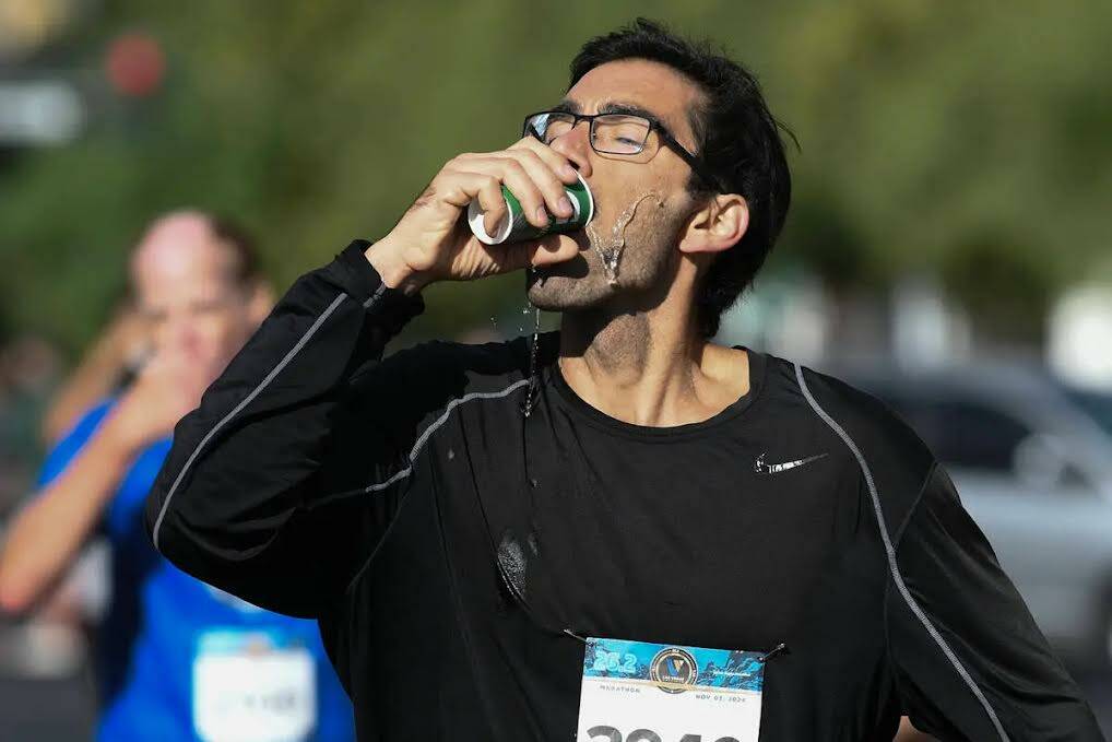 Un participante toma un vaso de agua durante el Maratón de Las Vegas del domingo 3 de noviembr ...