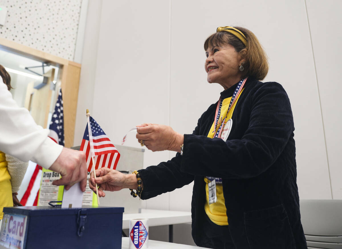 La voluntaria Luz Salter reparte calcomanías a los electores en un centro de votación en la E ...