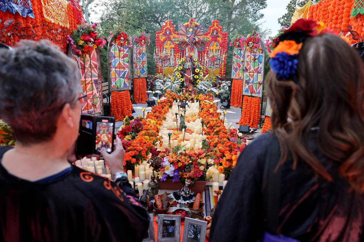 La gente observa la ofrenda, Luz Sagrada, durante la celebración del Día de los Muertos en Sp ...