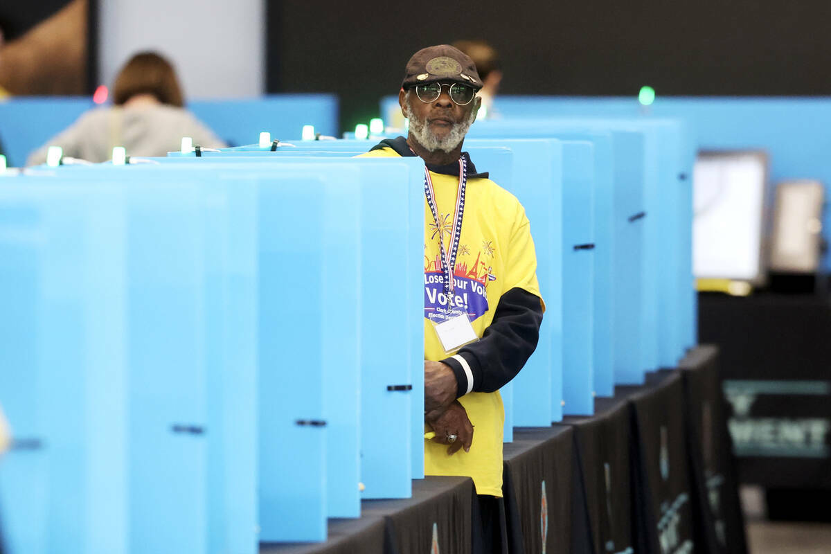 Empleados electorales ayudan a la gente a emitir su voto en el Allegiant Stadium, en Las Vegas, ...