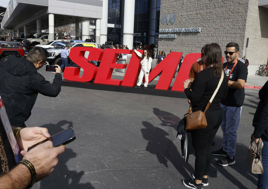 Asistentes posan para una foto en un letrero de SEMA durante el primer día de SEMA en el Centr ...