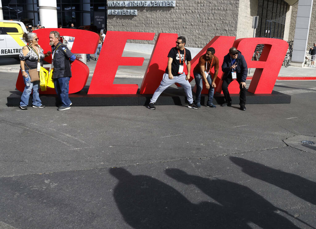 Asistentes posan para una foto en un letrero de SEMA durante el primer día de SEMA en el Centr ...