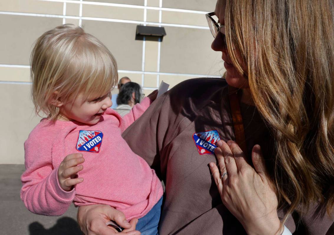 Lindsey Tiberti se coloca la calcomanía de ‘Yo voté’ en el pecho mientras la mira su hija ...