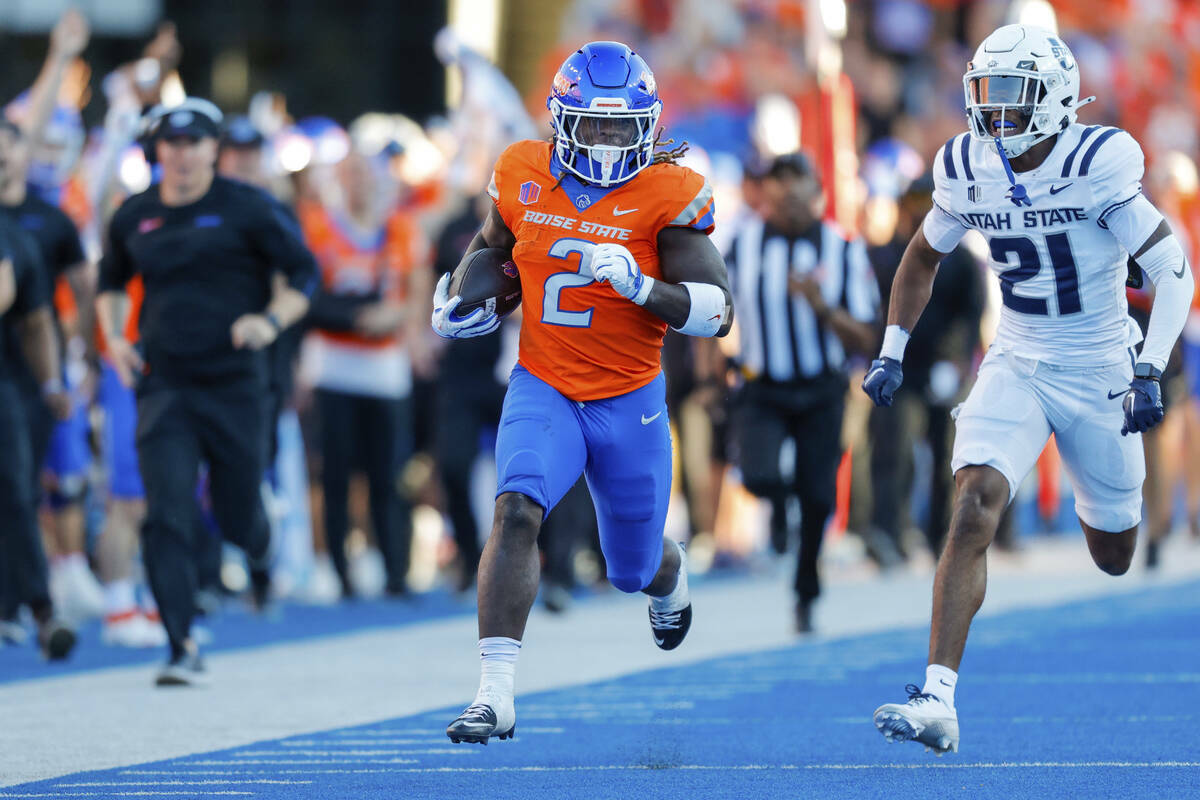 El running back de Boise State Ashton Jeanty (2) se escapa del safety de Utah State Malik McCon ...