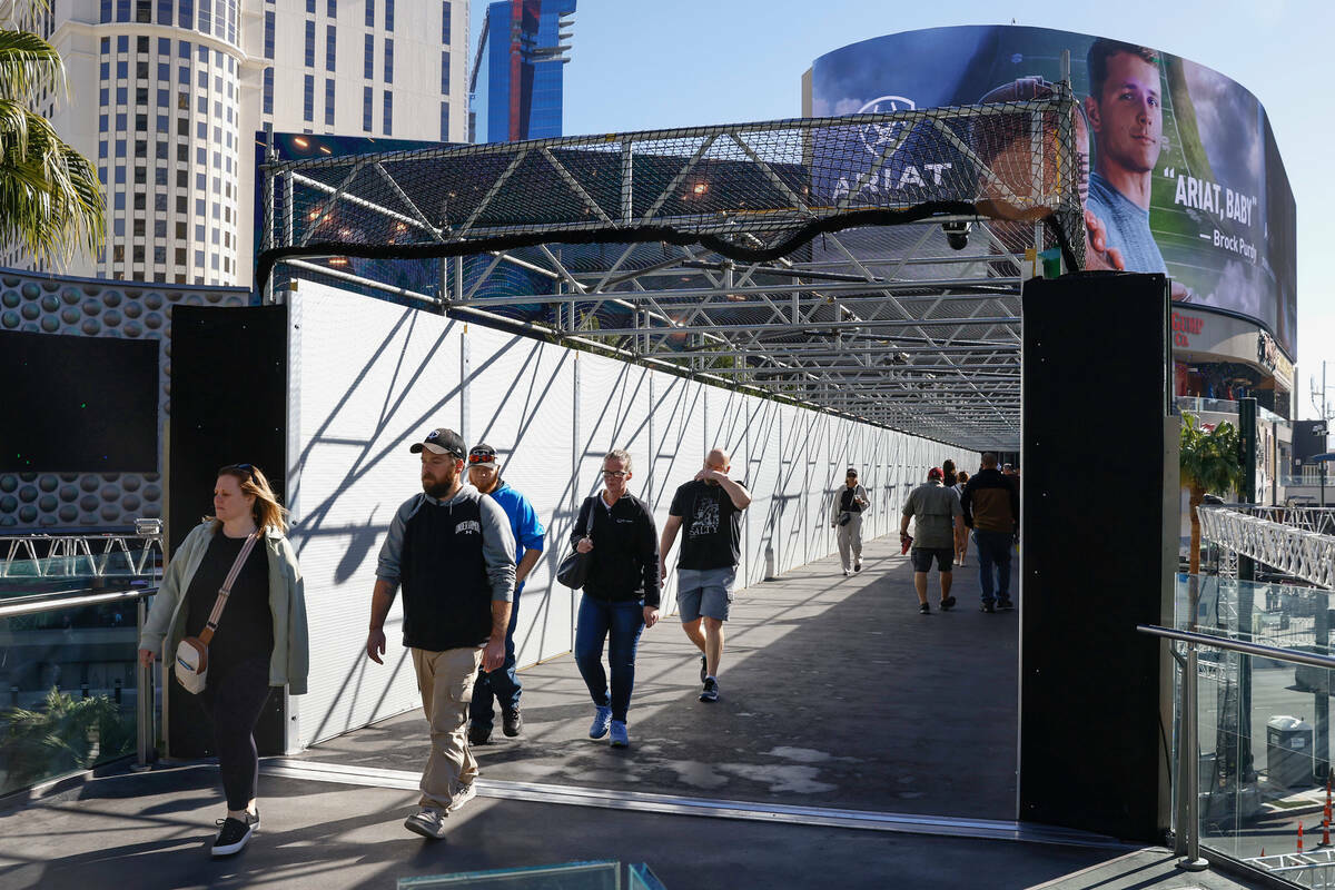 Peatones usan el puente peatonal sobre Las Vegas Boulevard, cerca del Cosmopolitan y el Planet ...