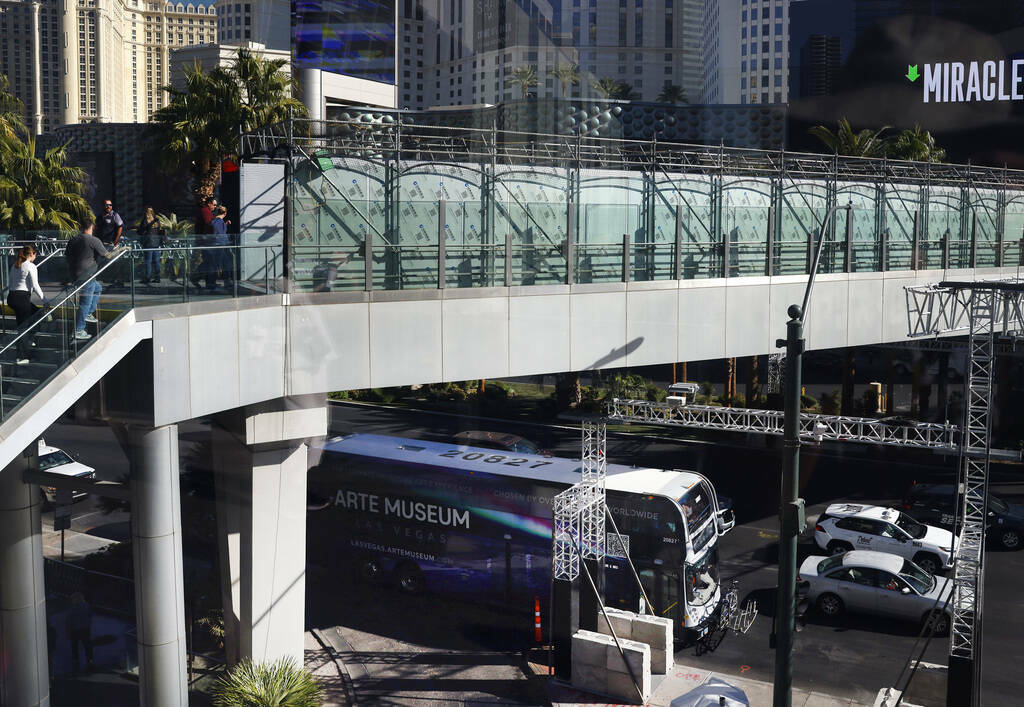 Peatones usan el puente peatonal sobre Las Vegas Boulevard, cerca del Cosmopolitan y el Planet ...