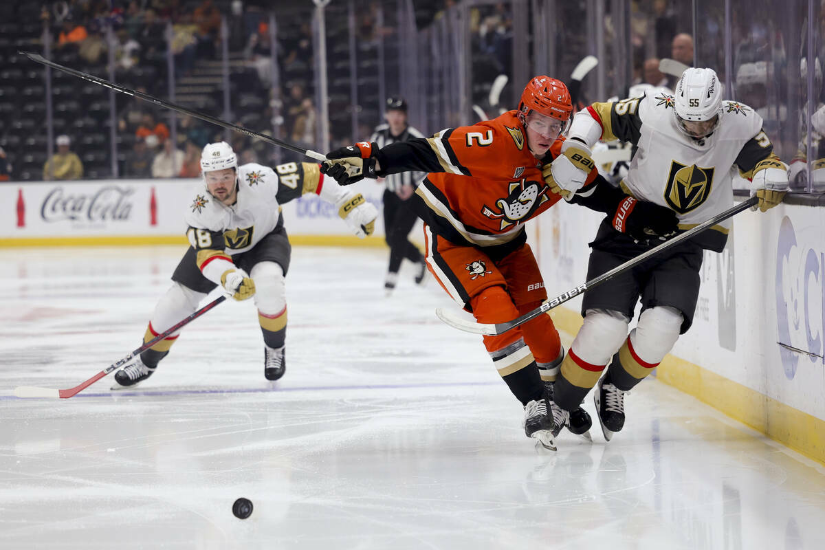 El defensa de los Anaheim Ducks, Jackson LaCombe, centro, y el ala derecha de los Vegas Golden ...