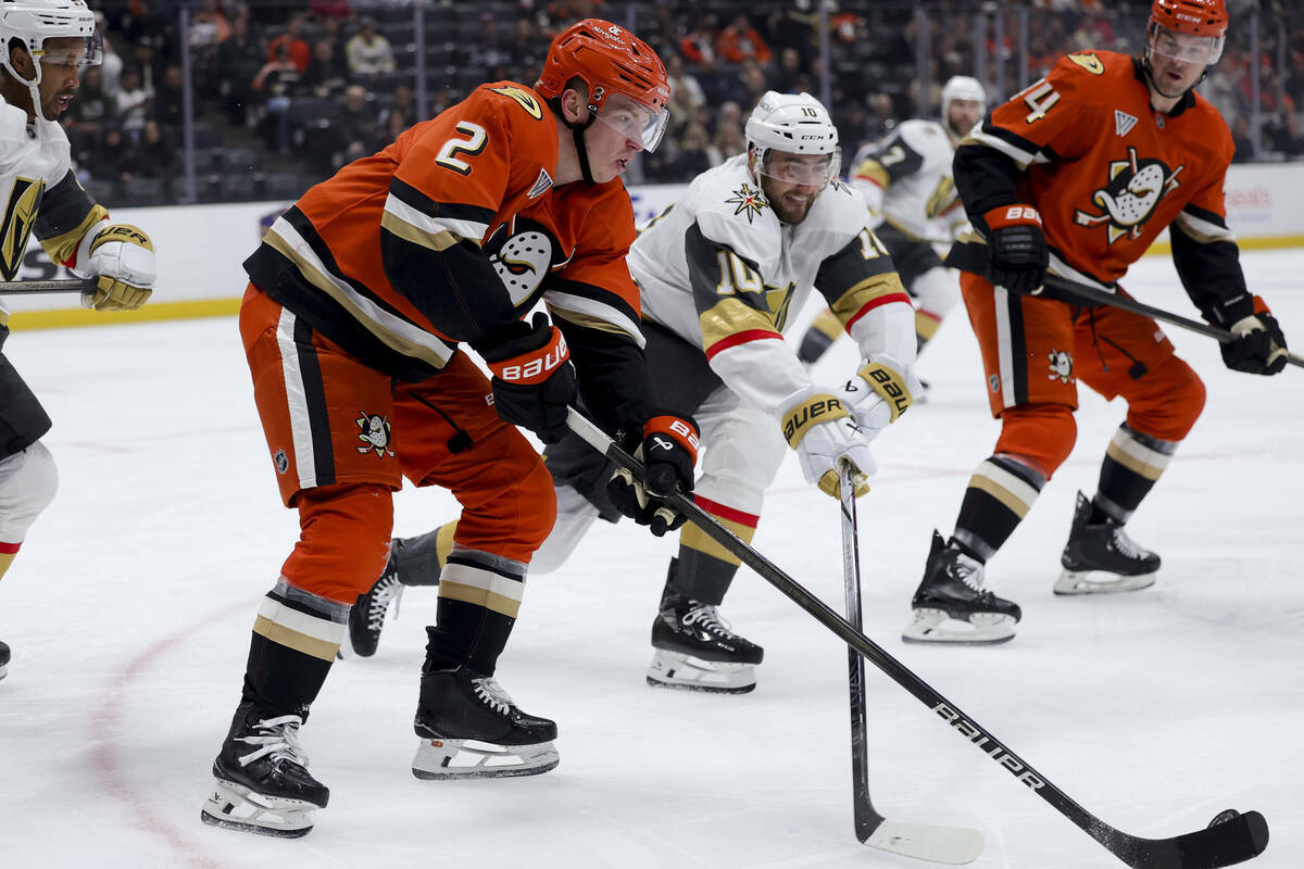 El defensa de los Anaheim Ducks, Jackson LaCombe (2), controla el puck contra el centro de los ...