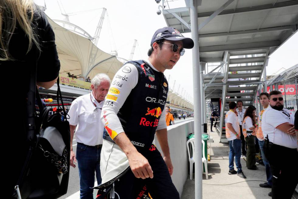 El piloto mexicano de Red Bull, Sergio Pérez, camina en el área de boxes durante la carrera p ...