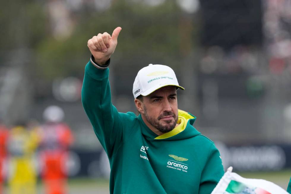 El piloto español de Aston Martin, Fernando Alonso, saluda a los espectadores durante el desfi ...