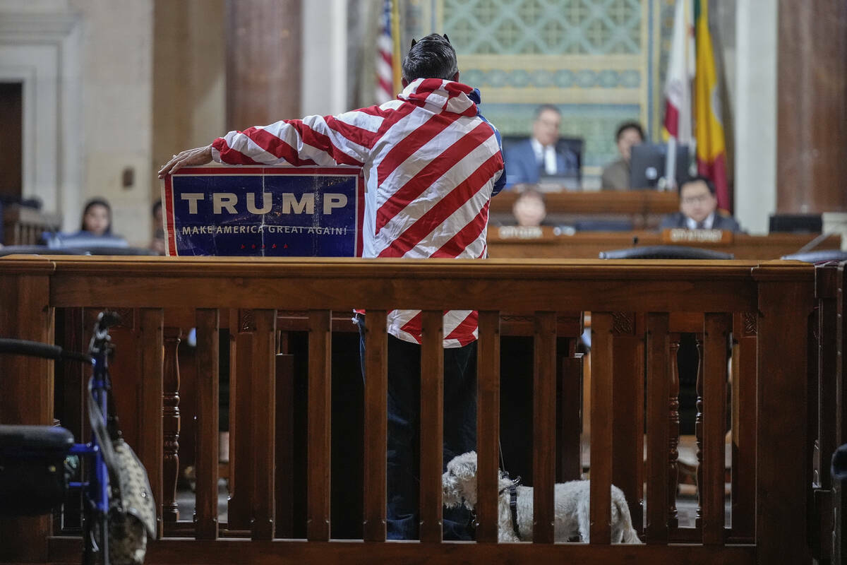 El manifestante Herman Armando muestra un cartel a favor de Trump durante su tiempo de comentar ...