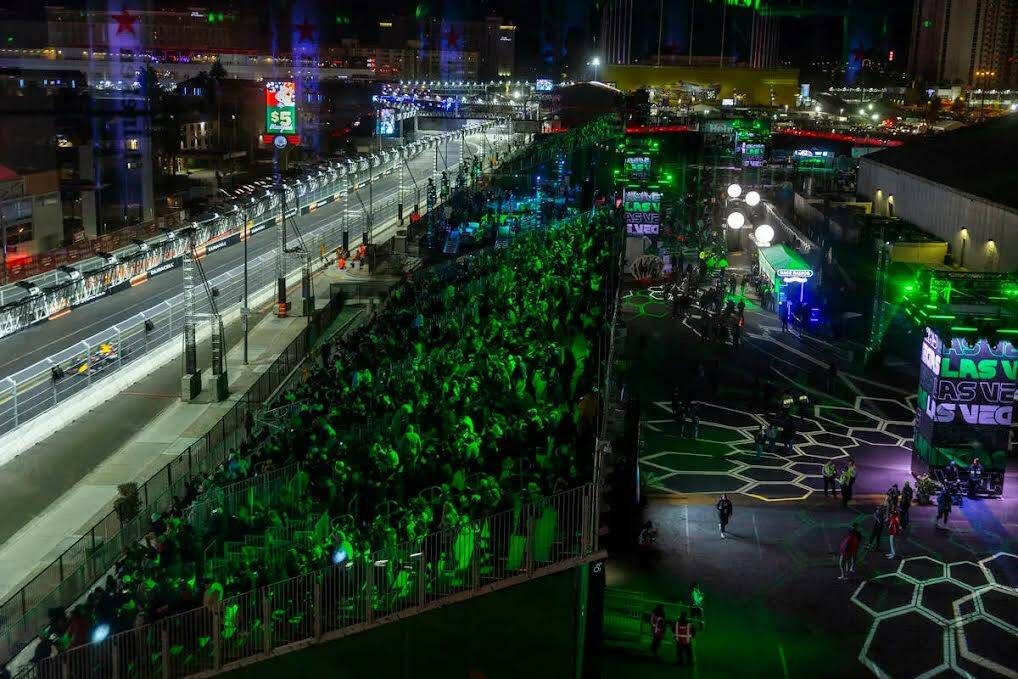 Los asistentes observan los autos navegar por la pista debajo de la torre Heineken durante la p ...