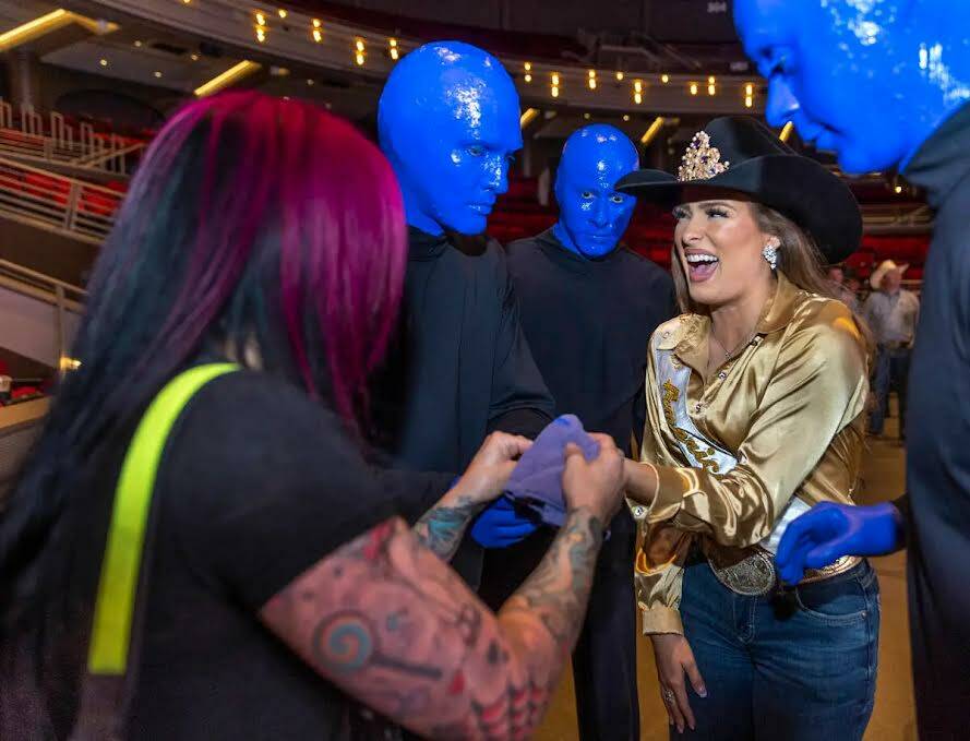 Miss Rodeo America, Kennadee Riggs, ríe mientras le retiran un poco de pintura azul de los ded ...