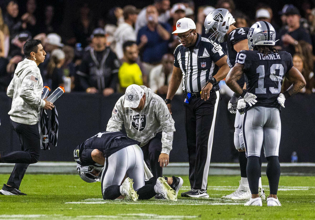 El quarterback de los Raiders Gardner Minshew (15) es derribado después de un sack con una les ...