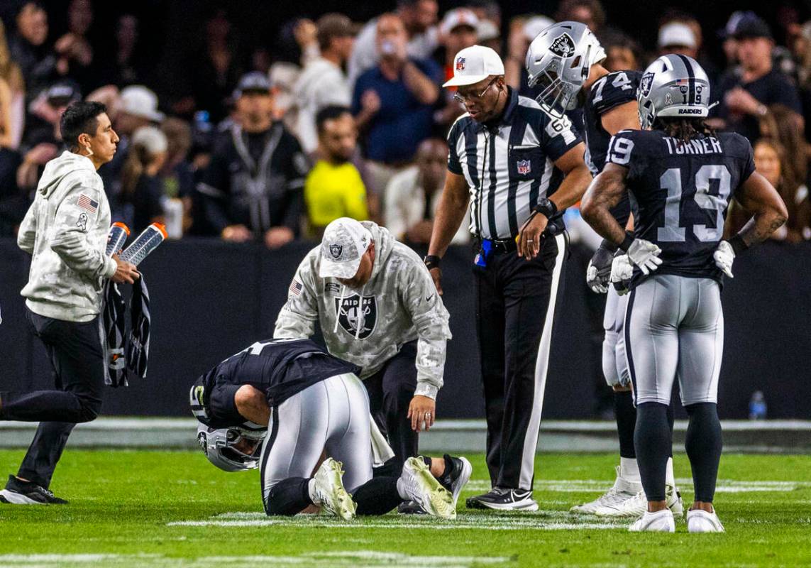 El quarterback de los Raiders Gardner Minshew (15) es derribado después de un sack con una les ...