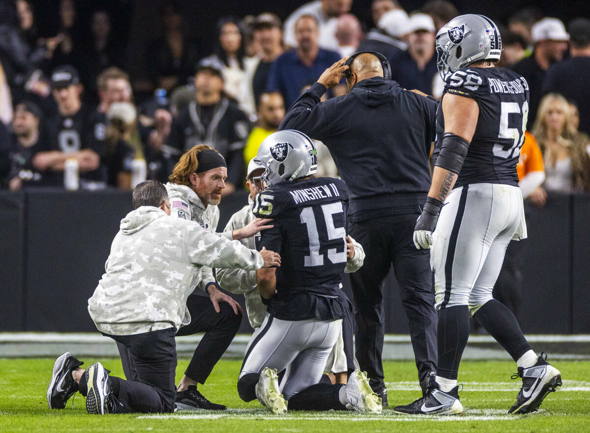 El quarterback de los Raiders Gardner Minshew (15) es derribado después de un sack con una les ...