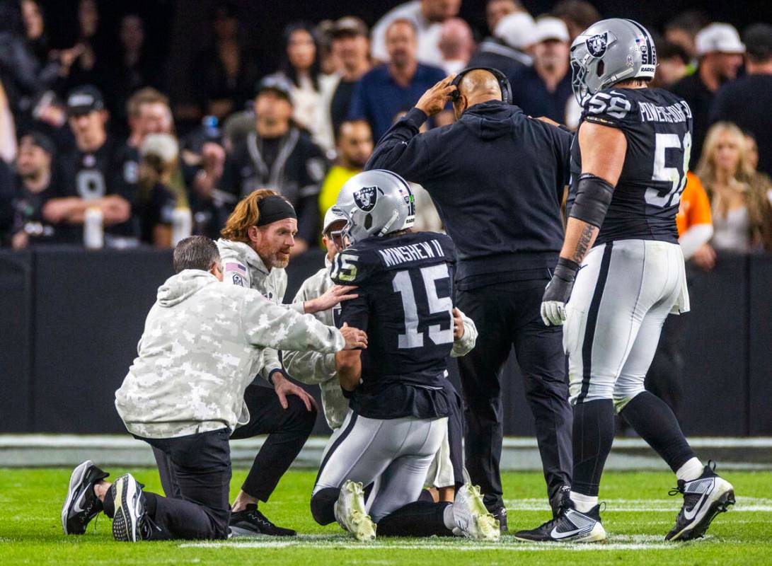 El quarterback de los Raiders Gardner Minshew (15) es derribado después de un sack con una les ...