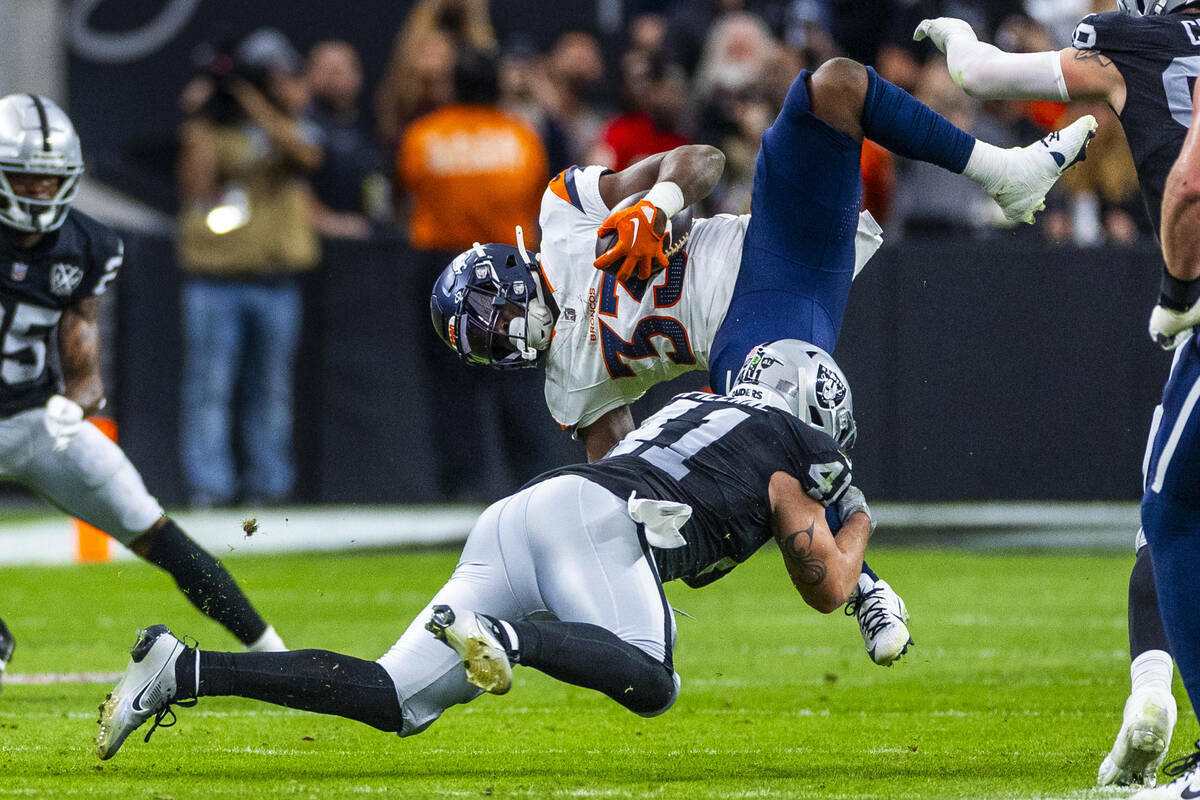 El linebacker de los Raiders Robert Spillane (41) derriba al running back de los Denver Broncos ...