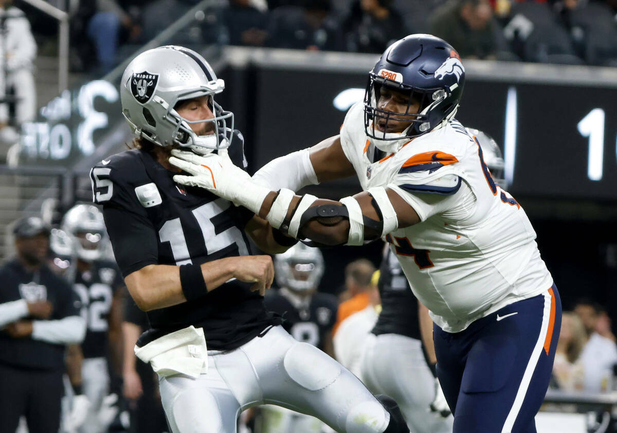 El quarterback de los Raiders Gardner Minshew (15) lanza bajo la presión del tackle defensivo ...