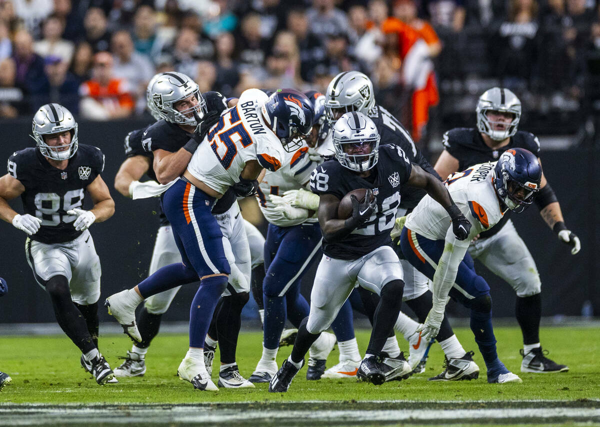 El running back de los Raiders Sincere McCormick (28) atraviesa la línea y avanza por el campo ...