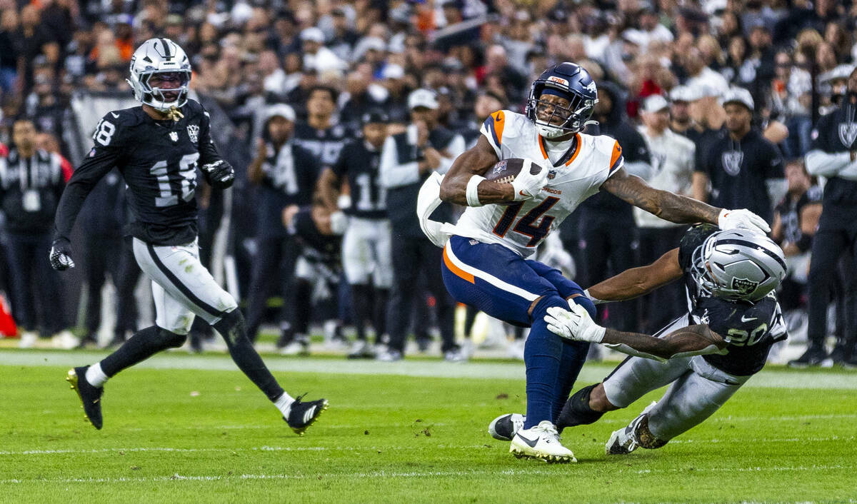 El wide receiver de los Denver Broncos Courtland Sutton (14) se sacude al safety de los Raiders ...