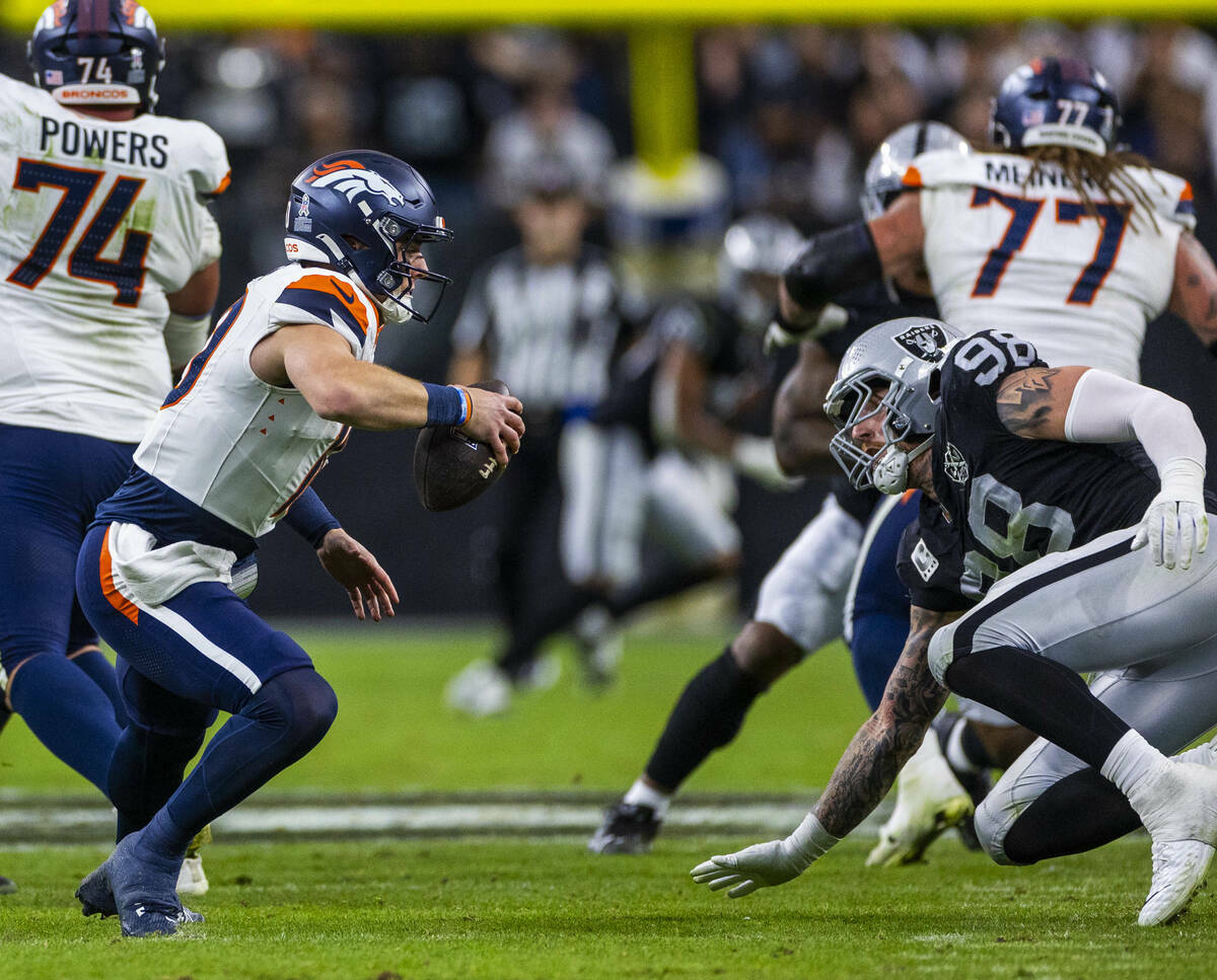 El defensive end de los Raiders Maxx Crosby (98) corta el paso al quarterback de los Denver Bro ...