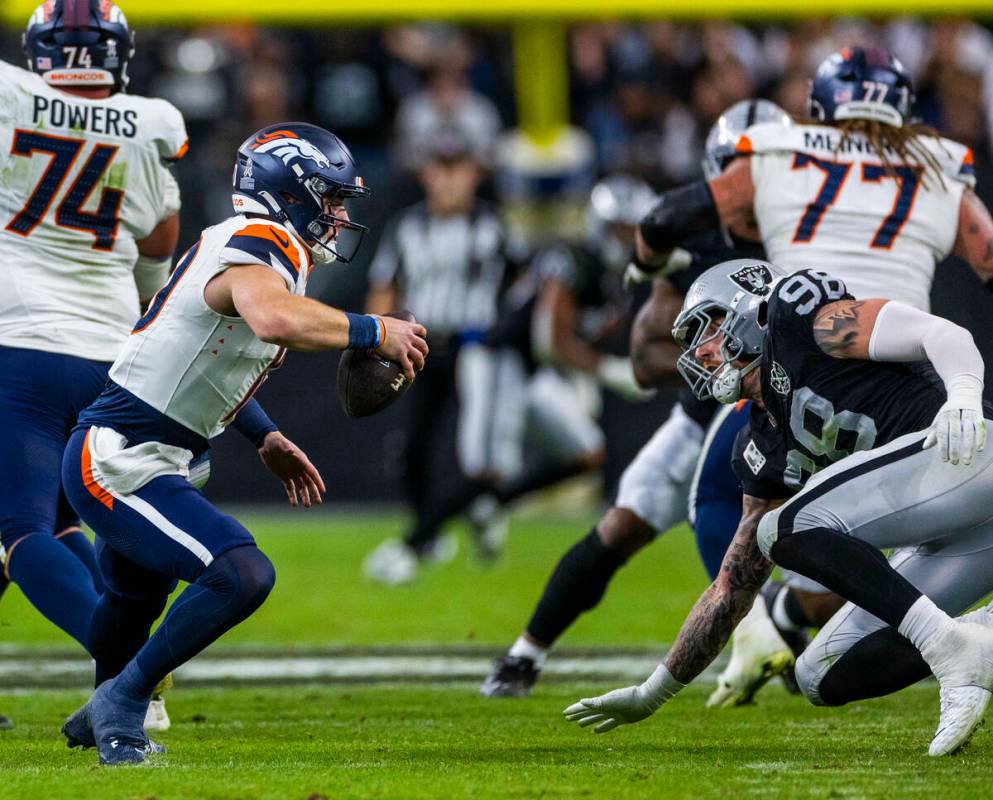 El defensive end de los Raiders Maxx Crosby (98) corta el paso al quarterback de los Denver Bro ...