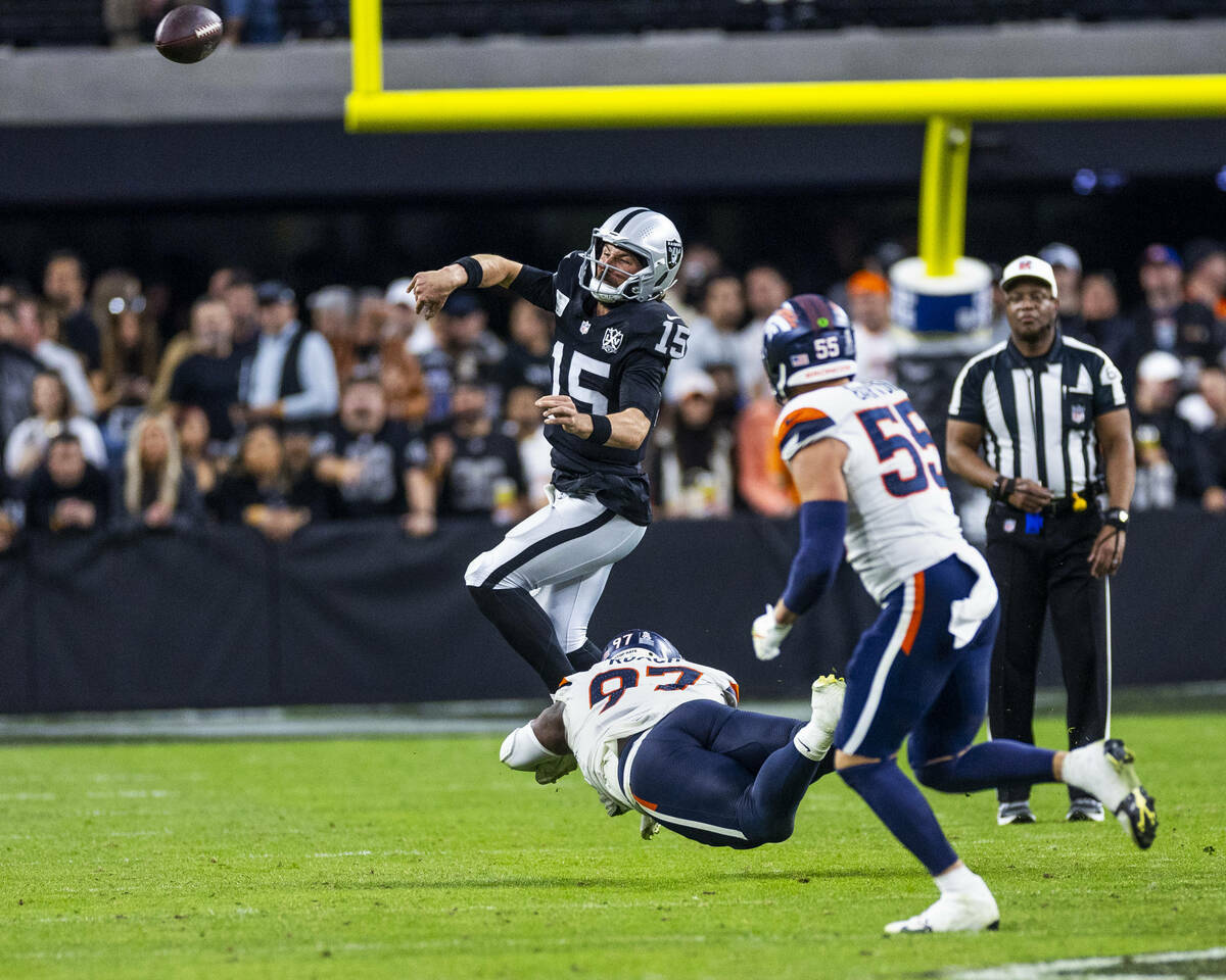 El quarterback de los Raiders Gardner Minshew (15) se deshace del balón en una jugada mientras ...