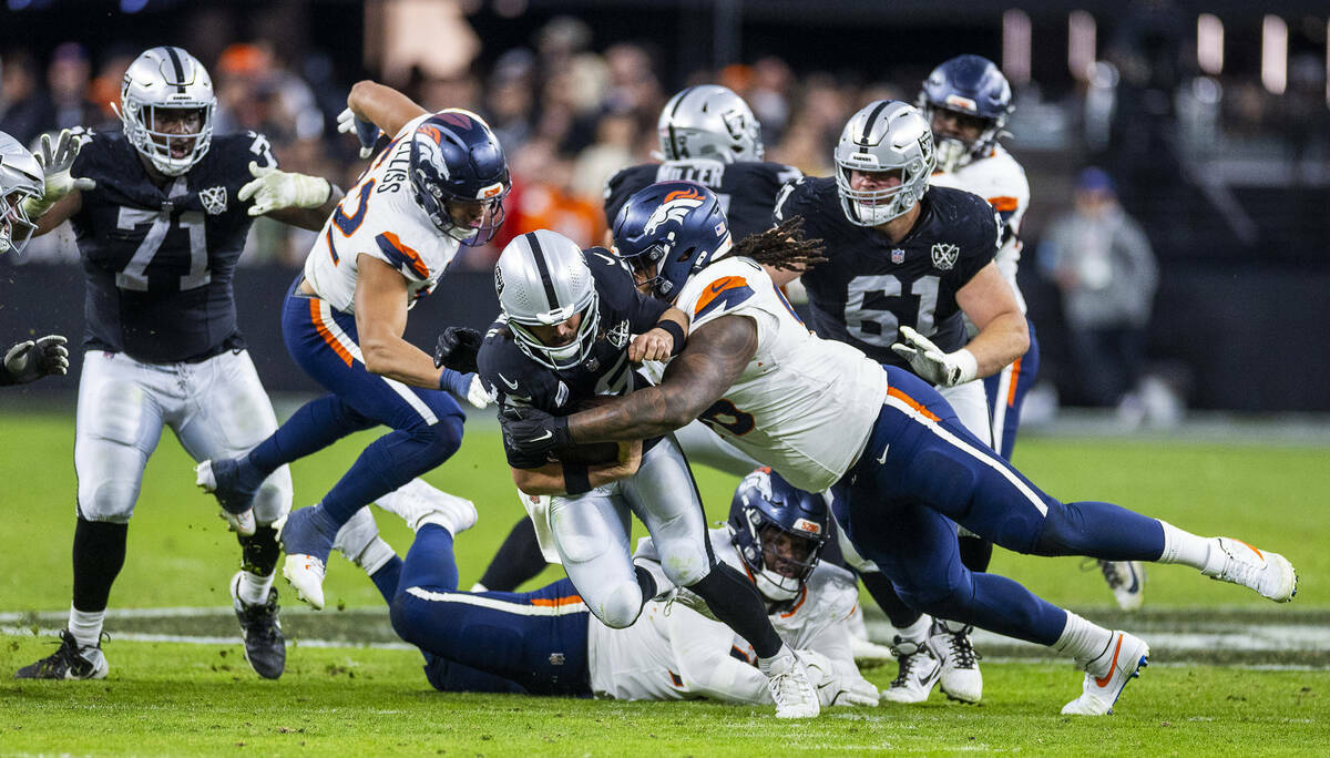 El quarterback de los Raiders Gardner Minshew (15) es derribado por el defensive end de los Den ...