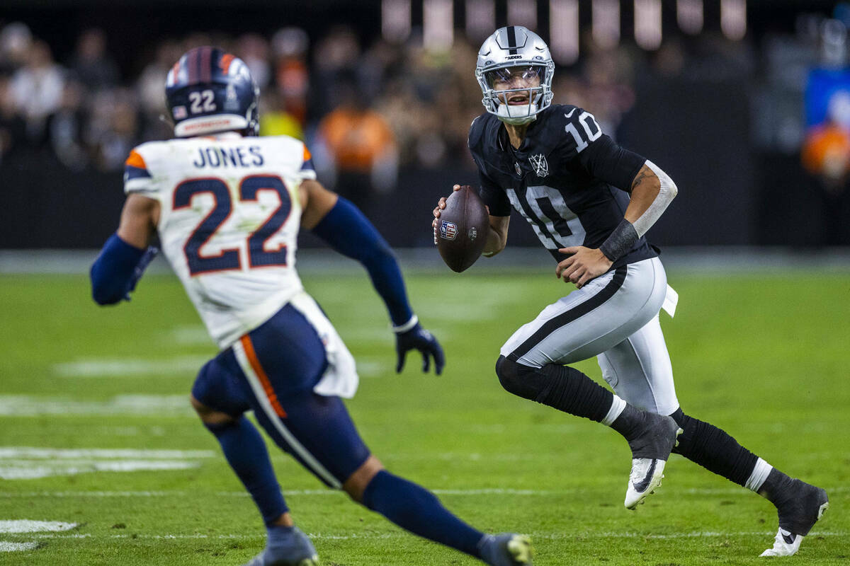 El quarterback de los Raiders Desmond Ridder (10) intenta un pase mientras el defensa de los De ...