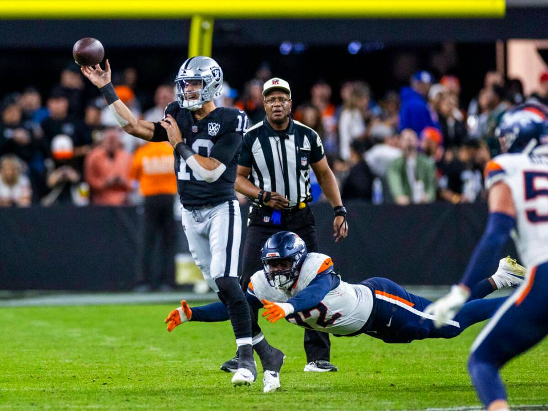 El quarterback de los Raiders Desmond Ridder (10) recibe un pase ante la presión del linebacke ...