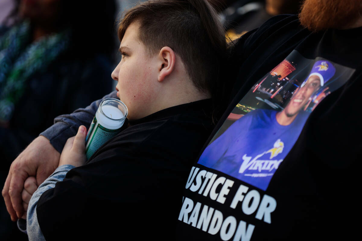 Elwood Pender, de 12 años, se apoya en su padre, Lowell, durante una vigilia por Brandon Durha ...